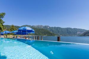 梅利德里维埃拉酒店 的一个带蓝色遮阳伞和水体的游泳池