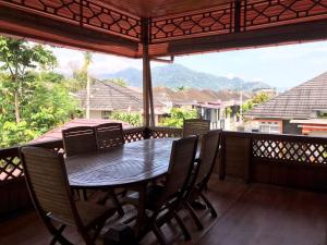 KampungdurianPalanta Roemah Kajoe Syariah Villa的门廊上设有桌椅,享有美景