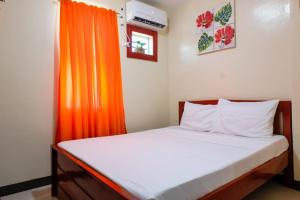 卡加盐德奥罗Downtown Suites CDO的一间卧室配有一张带橙色窗帘的床