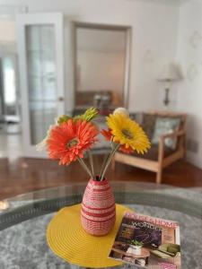 米西索加Glengarry Haus Home Away From Home的玻璃桌上带鲜花的红色花瓶