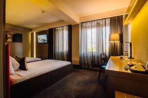 特尔古穆列什广场V行政酒店的酒店客房设有一张床、一张书桌和窗户。