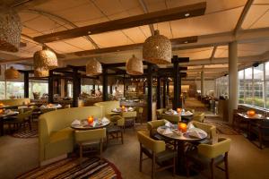 艾尔斯岩沙漠扬帆酒店的一间带桌椅的餐厅和一间酒吧