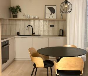 Prievoz3 izbový apartmán hneď pri letisku, možnosť rezervovať parking的厨房配有桌椅和水槽。