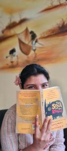 BharatpurNana Jungle Resort的女人在脸前拿着一本书