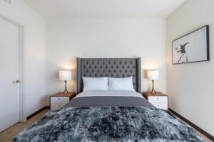 洛杉矶New WeHo Luxury Apartment的一间卧室配有一张大床和两盏灯