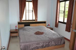 班佩Naluemon Village FH 3-4的一间卧室设有一张床和两个窗户。