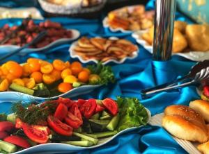 ZharkentГостиничный комплекс Жеты Казына的蓝色桌子,上面放有蔬菜和水果盘
