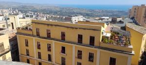 阿格里真托terrazze di montelusa的黄色的建筑,在阳台上种着鲜花
