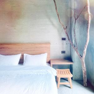 北埔沐目家 Xiang Jia Homestay的卧室配有白色的床和木凳