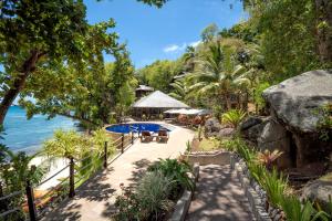 塞尔夫岛Cerf Island Resort的一座带游泳池、树木和水的度假村