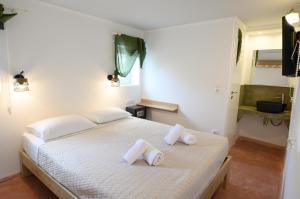 阿吉亚利拉其村公寓式酒店的卧室配有白色床和毛巾