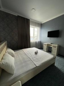 阿克托比Бутик-отель Мажор的酒店客房,配有床和电视