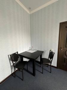 阿克托比Бутик-отель Мажор的一张黑桌子和两张椅子