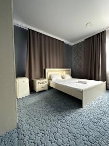 阿克托比Бутик-отель Мажор的一间卧室设有一张大床和一个窗户。