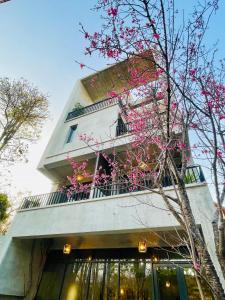 北埔沐目家 Xiang Jia Homestay的前面有粉红色花的建筑