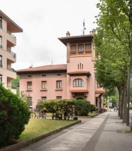 扎马亚Apartamento con garaje en el centro de Zumaia的一条城市街道上的粉红色大建筑