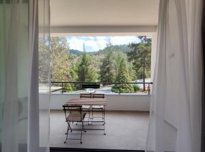 卡科佩特里亚Rifugio Retreat Bed&Breakfast的带阳台的带桌椅的房间