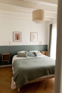 PloudalmézeauMen Louet E - Gîte de bord de mer的一间卧室配有一张带绿色床单的大床