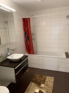 普福尔茨海姆ruhige Wohnung im Schwarzwald (Pforzheim, OT Würm)的一间带水槽、浴缸和卫生间的浴室