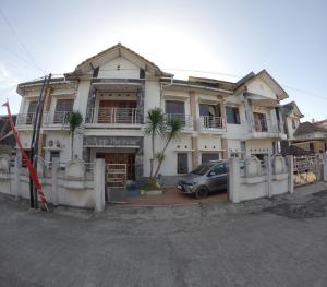 PotrojayanGrand Berbah Homestay Jogja的前面有停车位的房子