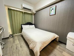 大阪A&C STAY Shinsaibashi的卧室配有白色的床和绿色窗帘
