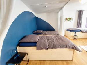 安贝格Viel Platz für Gruppen inkl. Waschmaschine, Hochstuhl und Playstation mitten in der Altstadt的一间卧室配有一张蓝色墙壁的床