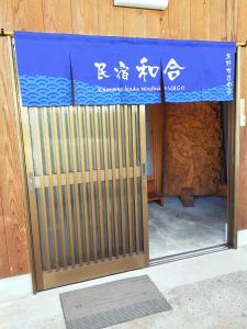 田边市民宿 和合 Minshuku WAGO的建筑物的门,上面有标志