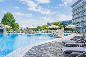 科沃布热格伊卡尔广场酒店的一座带椅子和遮阳伞的游泳池