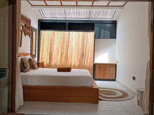 登巴萨Katang - Katang Guest House的一间卧室设有一张床和一个大窗户