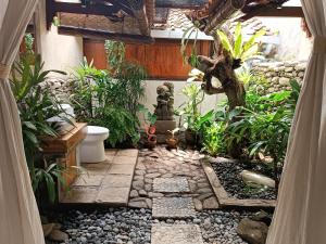 登巴萨Katang - Katang Guest House的一座种植了植物的户外花园以及石制步道