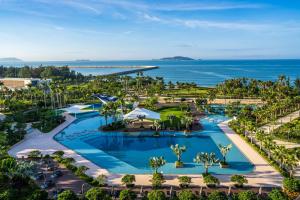 三亚三亚天丽湾凯悦酒店的享有带游泳池和海洋的度假村的空中景致