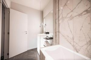布鲁日Boutique Hotel Sablon的白色的浴室设有浴缸和淋浴。