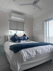 德班14 on Braemar的白色卧室配有一张带蓝色枕头的大床