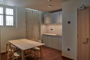 新加坡KINN Studios的厨房以及带桌椅的用餐室。
