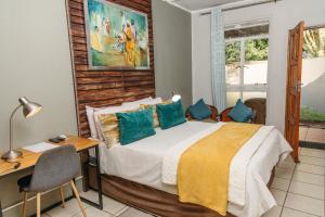 MkuzeBiweda Nguni Lodge的一间卧室配有一张床、一张书桌和一个窗户。