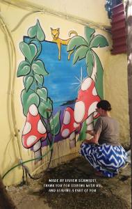 干尼亚Chania Hostel Youth的坐在壁画前的男人,手里拿着蘑菇