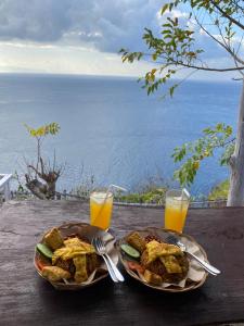 珀尼达岛Eco Tourist Dream Stay Tree House的两盘食物和两杯橙汁