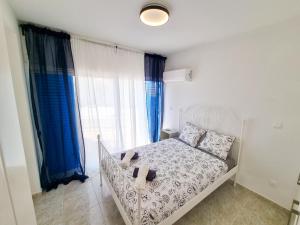 皮拉Beach Vibes Apartment的一间卧室配有白色的床和蓝色窗帘