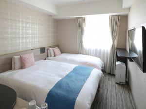 守山Vessel Inn Shigamoriyamaekimae的酒店客房设有两张床和窗户。