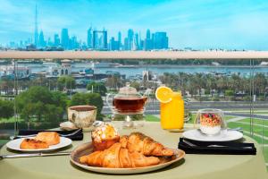 迪拜迪拜克里克万豪行政公寓的一张桌子,上面摆放着糕点和咖啡,享有城市美景。