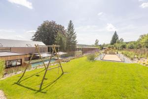 特纳维耶Villa Wood - Gîte de prestige en Ardennes - 10 personnes - Sauna, jacuzzi, piscine et billard的花园设有秋千