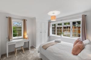 WorthingtonSilver Stag Properties, Luxurious 3 BR Bungalow的卧室配有一张床、一张书桌和窗户。