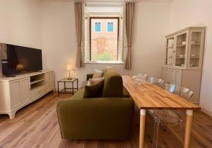 塔兰托Palazzo Pitagora的客厅配有绿色沙发和木桌