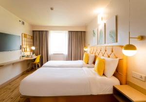 贾姆穆Bloom Hotel - Jammu的酒店客房配有两张床和一张书桌