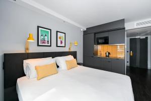 海德堡Staycity Aparthotels Heidelberg的卧室配有带橙色枕头的大型白色床