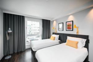 海德堡Staycity Aparthotels Heidelberg的配有窗户的酒店客房内的两张床