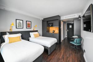 海德堡Staycity Aparthotels Heidelberg的酒店客房配有两张床和一张书桌