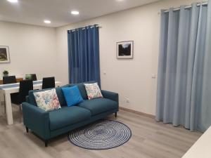 库拉尔-达斯弗雷拉斯Coração da Madeira的客厅配有蓝色的沙发和桌子