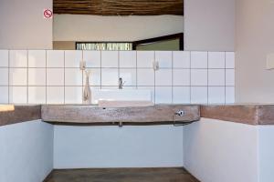 塞斯瑞姆At Kronenhof Campsites的白色瓷砖墙内带水槽的浴室