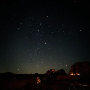 瓦迪拉姆Bedouin bunch camp的坐在星空下长凳上的一对夫妇